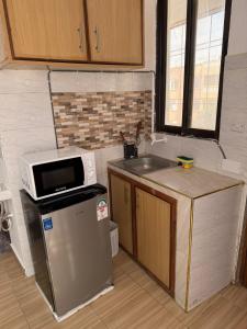 a kitchen with a microwave on top of a refrigerator at JnG HOMES in Malindi