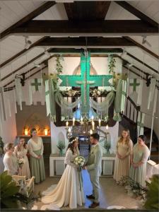 a bride and groom standing in front of a cross at Ostsee-Rittergut-Rügen - BinzHotel & OrdensKapelle in Binz