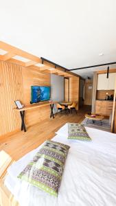 a bedroom with a white bed and a tv on a wall at Apartment Vučko Lux C334 Private host in Jahorina