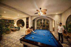 a man and a woman playing a game of pool at HELLO VILLA & SPA in Hue