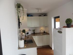 a kitchen with white cabinets and a sink at Stunning Ocean Views in Puerto de Mogan in Puerto de Mogán