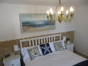 a bedroom with a bed with pillows and a chandelier at Stunning Ocean Views in Puerto de Mogan in Puerto de Mogán