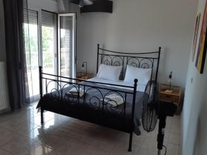 a black bed with white pillows in a bedroom at Villa Belvedere Flogita in Flogita