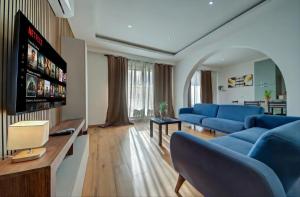 a living room with blue couches and a flat screen tv at Tigné Seafront Apartments & Penthouse with Heated Jacuzzi in Sliema