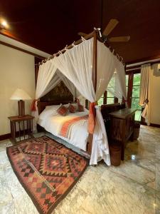a bedroom with a bed with a canopy at Baan Na Villa in Satuk +10 photos