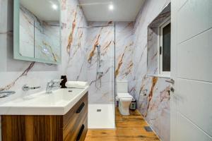 a bathroom with a sink and a toilet at Tigné Seafront Apartments & Penthouse with Heated Jacuzzi in Sliema
