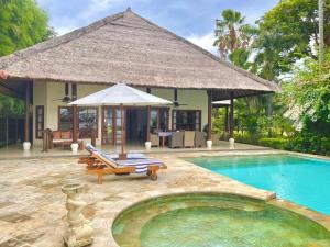a villa with a swimming pool and a house at Villa Nirwana in Lovina