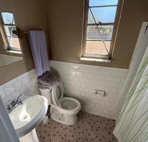 a bathroom with a toilet and a sink at Cozy Cove inn in Saint Cloud