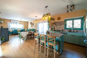 a kitchen with green cabinets and a table with chairs at בריאה אירוח בטבע in Sha'al