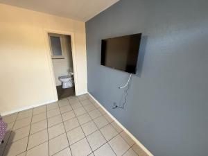 a bathroom with a toilet and a television on the wall at Cozy Cove inn in Saint Cloud