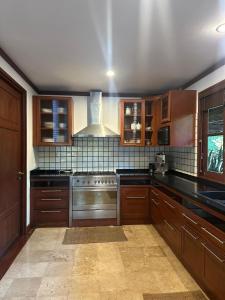a kitchen with wooden cabinets and a stove top oven at Baan Na Villa in Satuk