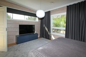 a bedroom with a bed and a flat screen tv at Villa Kannas 1 in Juuka