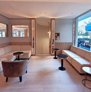 a living room with a couch and tables at Vittoria Parc Hotel in Bari