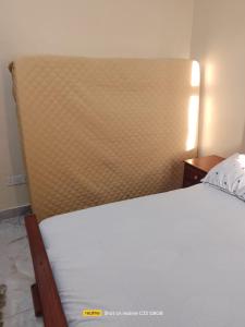 a bed in a bedroom with a large headboard at Luxury Homes in Mtwapa