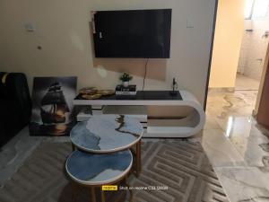 a living room with a tv and a table at Luxury Homes in Mtwapa