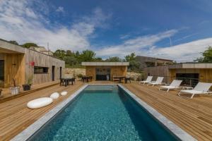 a house with a swimming pool and a wooden deck at La Possibilité d'une Ile in Apt