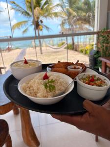 a tray with rice and other food on a table at Pousada Amarílis in Barra de Santo Antônio