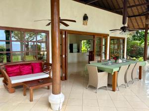a patio with a couch and a table and chairs at Villa Nirwana in Lovina