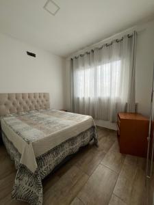 a bedroom with a large bed and a window at Casa com Piscina em Xangri-Lá RS in Xangri-lá +21 photos