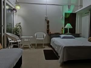 a bedroom with two beds and a table and chairs at BiJOY VILLA in Guwahati
