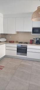 a kitchen with white cabinets and a stove top oven at Casa de Melides in Melides +25 photos