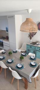 a dining room table with chairs and a chandelier at Casa de Melides in Melides