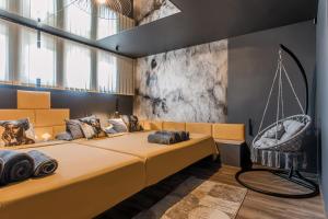 a bedroom with a large yellow bed and a swing at Greyhouse Apartments in Harkány