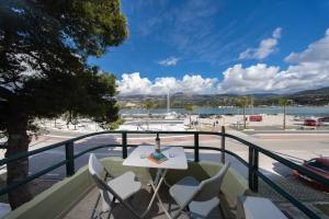 a table and chairs on a balcony with a view of a harbor at Myros Studios in Argostoli