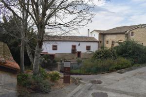 a white house with a tree in front of it at Ezpeleta Palace in Berriozar