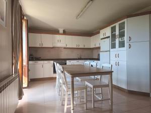 a kitchen with a table and white cabinets and white chairs at Ezpeleta Palace in Berriozar