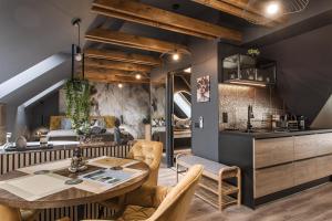 a kitchen and living room with a table and chairs at Greyhouse Apartments in Harkány