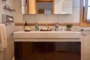 a bathroom with a white sink and a mirror at Laax Cozy Apartment - Ski Bus - Fireplace in Laax