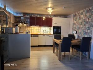 a kitchen with a wooden table and a dining room at Ferienwohnung Seeblick in Langweiler