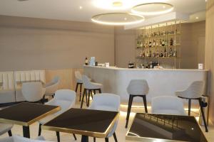 a restaurant with tables and chairs and a bar at Vittoria Parc Hotel in Bari