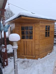 a wooden shed with snow on the roof at Ferienwohnung Seeblick in Langweiler