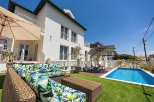 a villa with a swimming pool and a house at BeGuest Estoril Guesthouse in Estoril