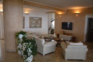 a living room with wicker chairs and a table at Hotel Bagni Lido in Vada