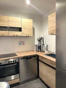 a kitchen with stainless steel appliances and wooden cabinets at Three bedroom apartment in Dingolfing