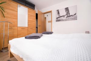 a bedroom with a large white bed and wooden cabinets at Seewind W04 in Laboe