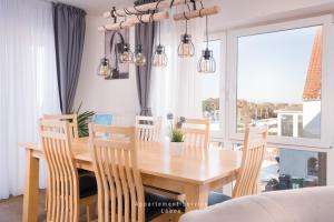 a dining room with a wooden table and chairs at Seewind W04 in Laboe