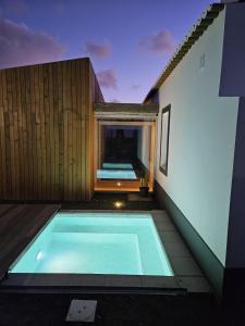 a swimming pool on the side of a building at Grão de Areia - Mosteiros - 50m da praia - piscina privada in Mosteiros