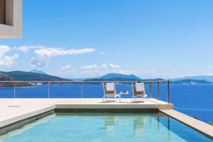 two chairs and a swimming pool with a view of the water at VILLA ODISSOS - Private Paradise with 2 infinity pools & Sea access in Sivota +35 photos