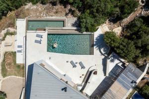 an overhead view of a swimming pool on a house at VILLA ODISSOS - Private Paradise with 2 infinity pools & Sea access in Sivota
