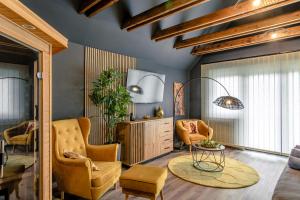 a living room with two chairs and a table at Greyhouse Apartments in Harkány