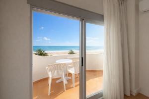 a view of the beach from a room with sliding glass doors at Hotel RH Riviera - Adults Only in Gandía
