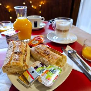 a table with a plate of toast and coffee and orange juice at Hotel du Commerce et de Navarre in Lourdes