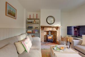 a living room with a couch and a fireplace at Rose Cottage in Docking
