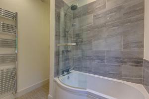 a bathroom with a bath tub and a shower at Rose Cottage in Docking +19 photos