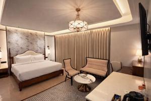 ein Hotelzimmer mit Bett, Tisch und Stuhl in der Unterkunft AMBROSE Hotel in Mohali + 32 Fotos