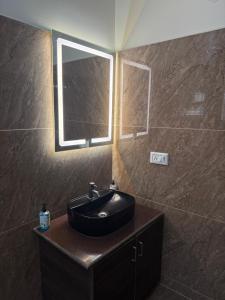 a bathroom with a black sink and a window at Hotel Fortune 36 in Bangalore